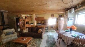 A cozy living room with a sofa, coffee table, and a dining area with a table and chairs.