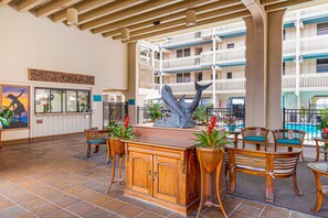 Relax in a spacious area with a high ceiling, featuring a central bar and comfortable seating.