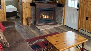 A cozy cabin interior with a wooden ceiling, a fireplace, a television, a sofa, and a door labeled "LAKE". - Updated Camp- 5 min  to Old Forge, 1st Lake views (Old Forge)