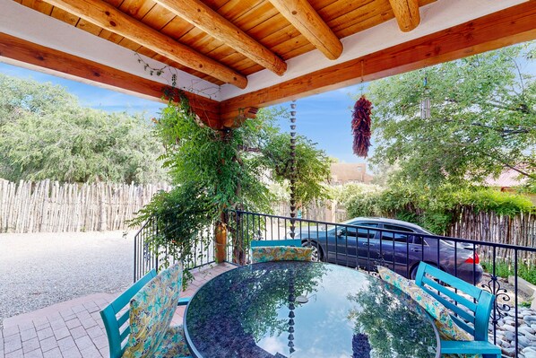 Relax in this serene outdoor seating area surrounded by a wooden ceiling with exposed beams and comfortable benches.