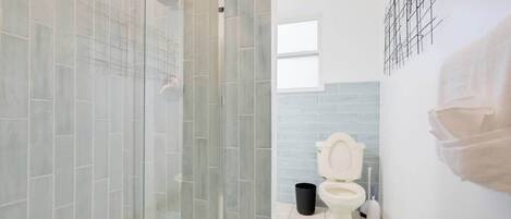 Ein Badezimmer mit Duschkabine, Toilette und Waschbecken.