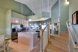 Enjoy cooking in this well-equipped kitchen with a central island, refrigerator, oven, and dishwasher.