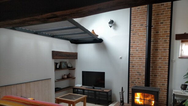 A cozy living room with a TV, a fireplace, and a wooden bench. - Country house between loire and sologne (Mézières-lez-Cléry)