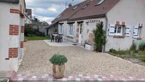 A residential area with a gravel driveway, a potted plant, and a patio table with chairs. - Country house between loire and sologne (Mézières-lez-Cléry)
