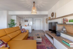 Ein modernes Wohnzimmer mit einer Couch, Couchtisch, Fernseher und Dekorationselementen.