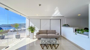 Ein modernes Interieur mit einer Couch, einem Glastisch und Meerblick.