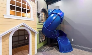 A play area with a blue slide and a small house-like structure. - Deluxe Mansion with Swim up Bar and Pool Slide at Reunion - AUGUST DISCOUNT! (Four Corners)
