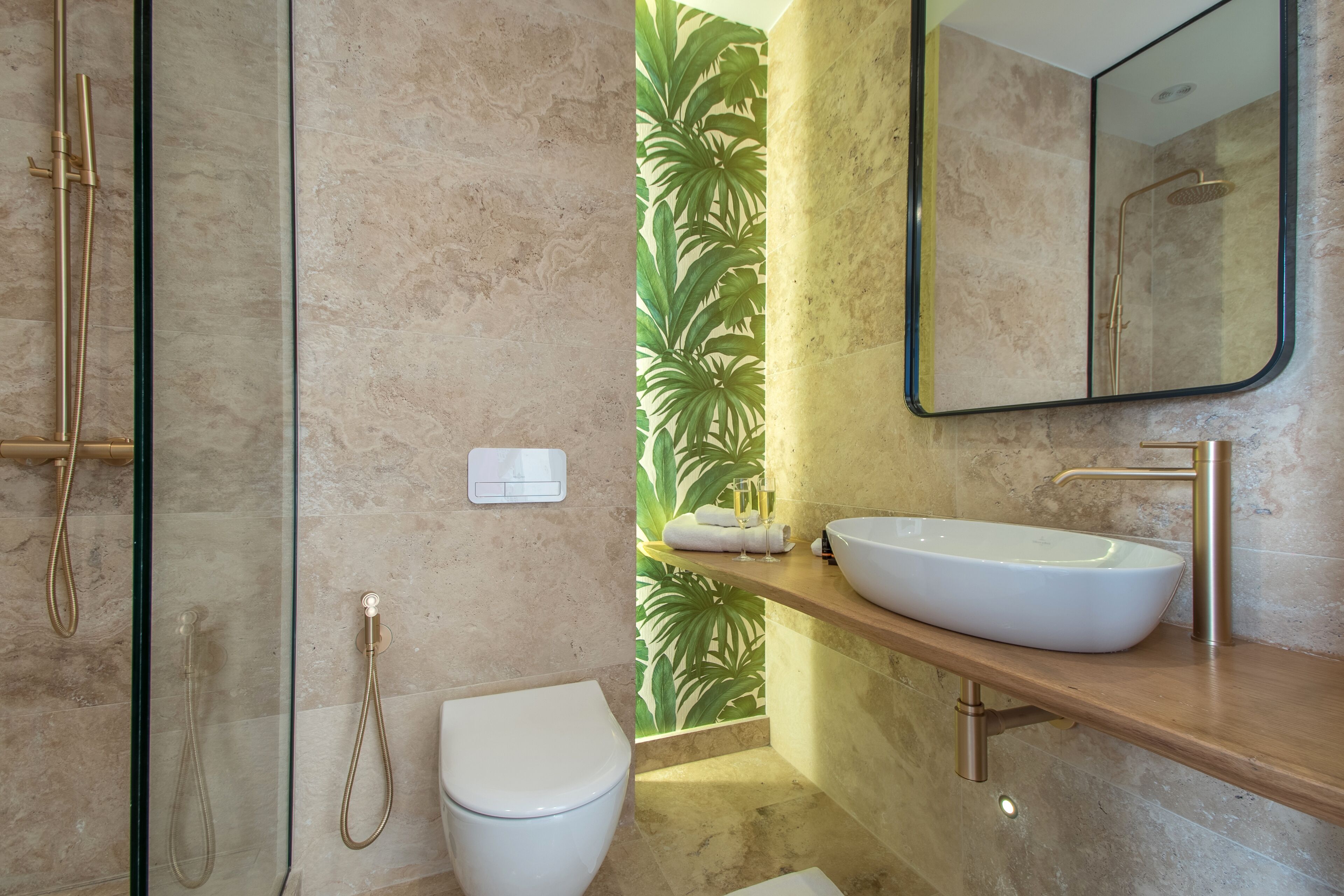 Une salle de bain moderne avec une douche à parois de verre, des toilettes blanches, un grand lavabo et un miroir.