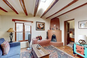 Télévision, cheminée, lecteur de DVD, livres