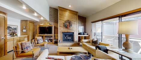 Télévision à écran plat, cheminée, lecteur de DVD, livres