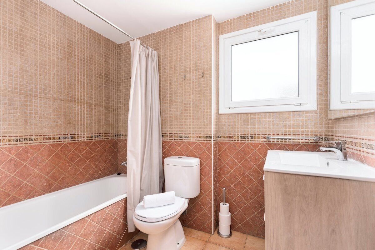 A bathroom with a bathtub, toilet, and sink.
