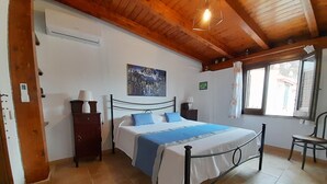 A bedroom with a bed, a nightstand, a dresser, a painting, a window, and a chair. - Villa Queen of the Sea - Top solarium and large garden (sciacca)