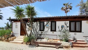 A building with a white facade, wooden shutters, and a thatched roof. - Villa Queen of the Sea - Top solarium and large garden (sciacca)