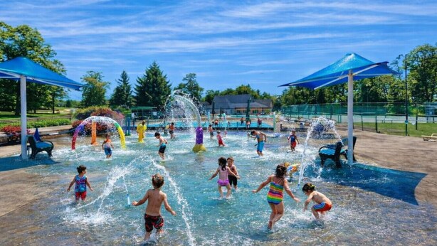 A water park with multiple water play areas and covered seating areas.