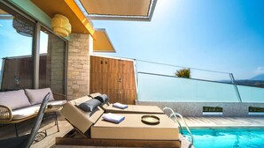 A modern outdoor pool area with lounge chairs, a sofa, and a dining table. - Oleas Suite Earth & Private Pool (Heraklion)