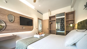 A modern hotel room with a large bed, a flat-screen TV mounted on the wall, a wooden wardrobe, and a mirror. - Oleas Suite Earth & Private Pool (Heraklion)
