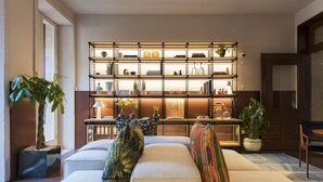 Una sala de estar moderna con una amplia estantería, asientos cómodos y plantas decorativas.