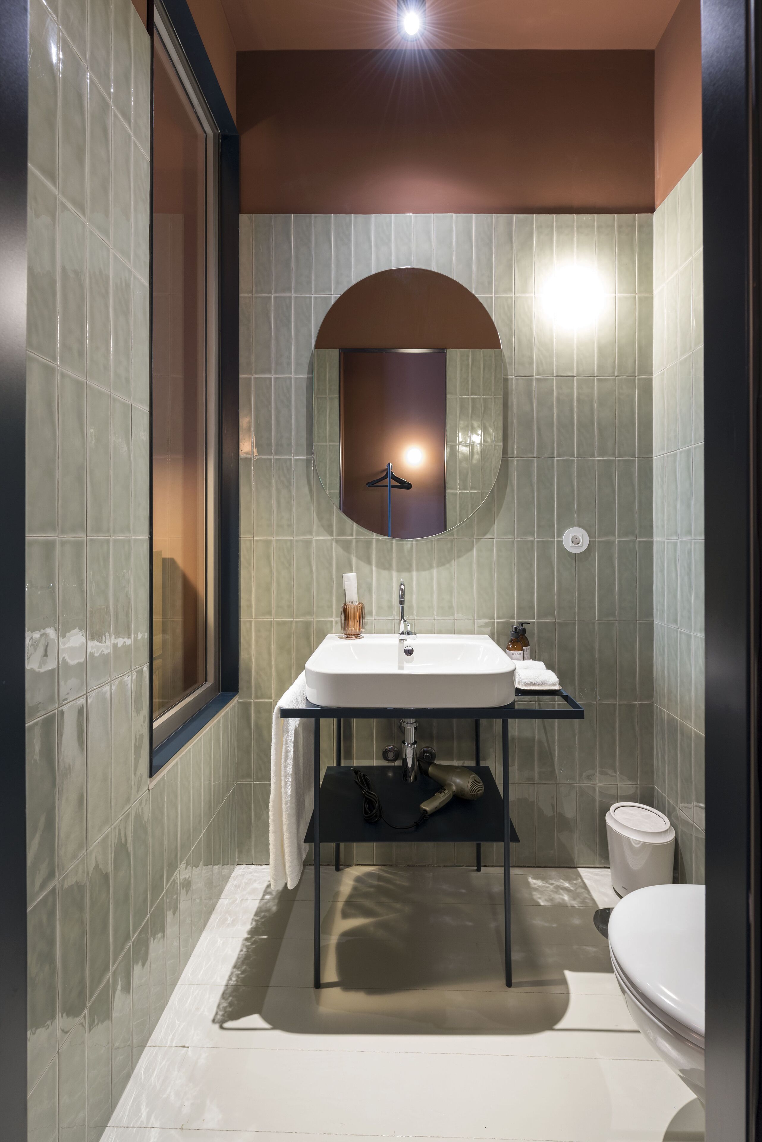 Un baño moderno con un espejo grande, un lavabo y un inodoro.