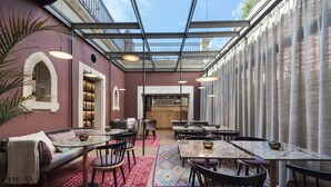 Un restaurante con techo de vidrio, mesas, sillas y un espacio de estar acogedor.