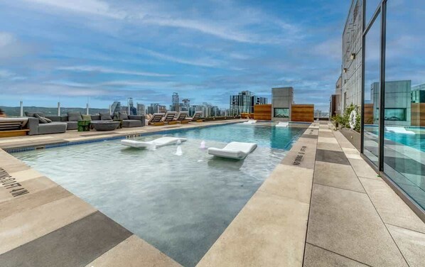 Una piscina en la azotea, sillones reclinables de piscina
