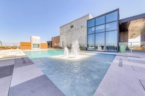 Una piscina en la azotea, sillones reclinables de piscina