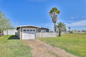 A single-story house with a garage, a small porch, and a palm tree in the yard.