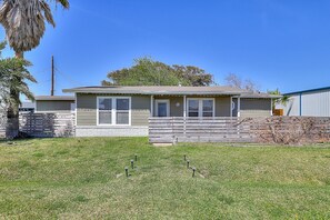 A single-story house with a front porch, a small front yard, and a garage.