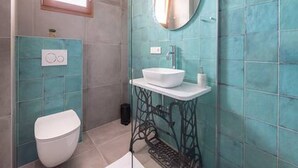 A bathroom with a white toilet, a sink with a mirror above it, and a window above the toilet. - Mamma mia luxury rooms - Double Room with Sea View (Trogir)