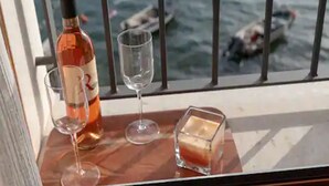 A table with a bottle of wine, two wine glasses, and a candle. - Mamma mia luxury rooms - Duplex Double Room with Sea View (Trogir)