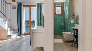 Een modern appartement met een trap, een balkon, een badkamer met een groene wand en een witte wastafel.