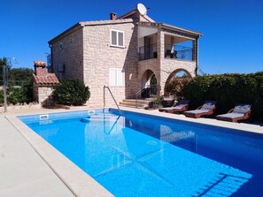 A stone building with a swimming pool, a balcony, and lounge chairs. - Apartment Villa Jakov - Two Bedroom Apartment with Terrace and Swimming Pool (Rogač)