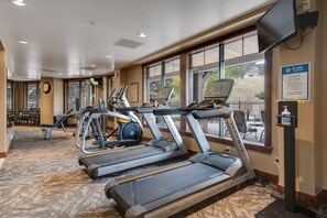 A fitness center with treadmills, weight machines, and dumbbells.