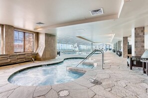 A spa area with a hot tub, stone flooring, and seating along the walls. - Modern Breckenridge Penthouse.  Ski-in/ski-out! (Breckenridge)