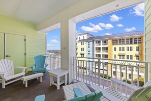 Enjoy the view from this balcony with a table and two Adirondack chairs.