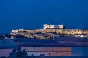 A historical building with classical architecture, situated on a hill with modern buildings in the foreground. - Parthenon dream, breathtaking views with free parking  (Αθήνα)