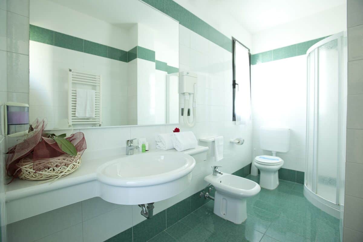 Une salle de bain moderne équipée d’un grand lavabo, d’un bidet, de toilettes et d’une douche.