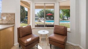 Una camera d'angolo con vista sulla piscina e area relax all'aperto.