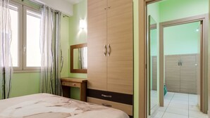 A bedroom with a bed, a wooden wardrobe, a mirror, and a window with curtains. - For a dream vacation to the Ionian Sea 5 sails (San Lorenzo  Reitani)