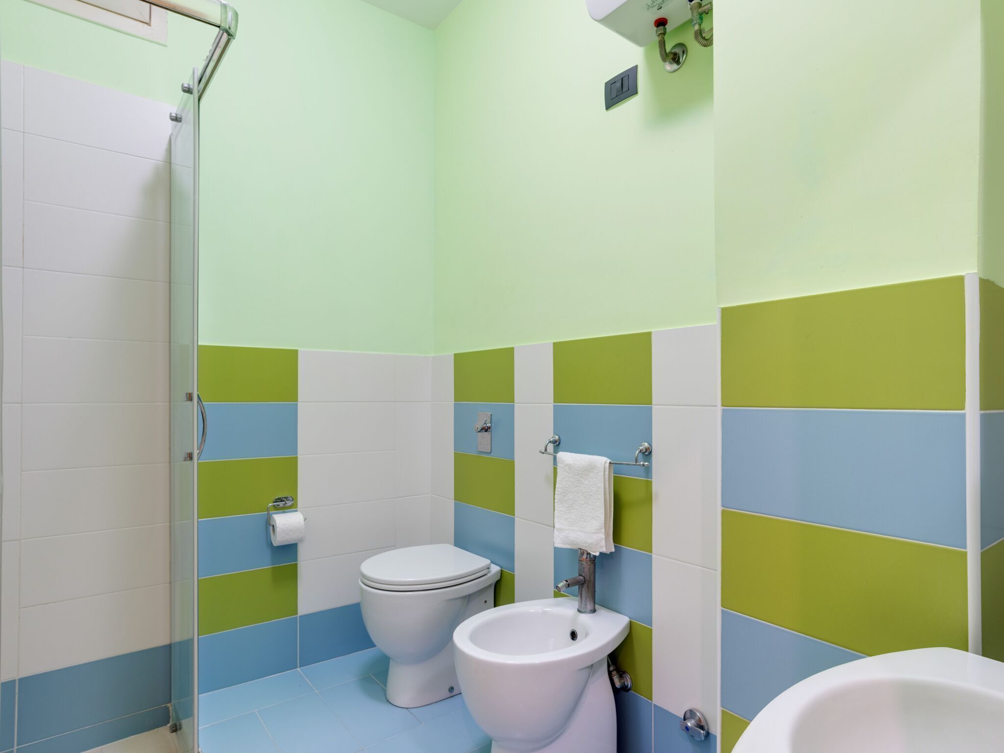 Ein Badezimmer mit Toilette, Bidet und Duschbereich.
