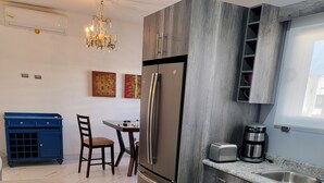 Eine moderne Küche mit Marmorboden, Edelstahlgeräten und einem blauen Schrank.