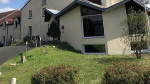 A modern building with a flat roof, a chimney, and a flagpole with a flag. - Hotel Le Drakkar (Pont-Audemer)