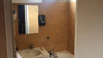 A compact bathroom with two sinks, a mirror, a towel rack, a fan, and a window.
