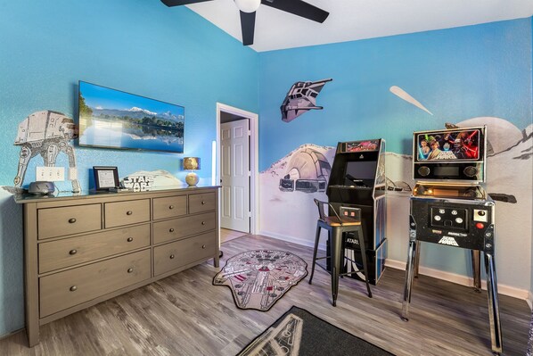A room with Star Wars-themed decor, including wall art and a console.