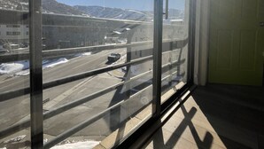 A room with large windows overlooking a snowy landscape and a road. - Cozy Freshly remodeled 1B/1B Retreat close to Main (Park City)