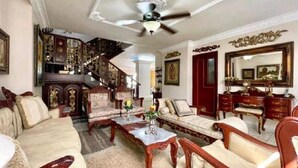 A traditional living room with a sofa, armchairs, a coffee table, and a staircase leading to an upper floor. - 8MG-1 MANSION EN CARTAGENA CERCA AL MAR (Cartagena)