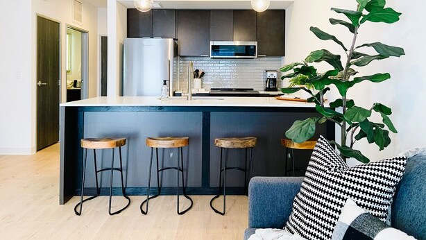 A modern kitchen with a central island, bar stools, and pendant lighting. - New Condo Walkable to Downtown Bozeman (Bozeman)
