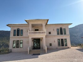 A two-story building with a symmetrical facade, large windows, and a central entrance with a decorative arch.