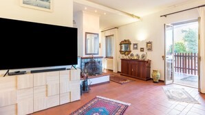 A spacious living room with a flat-screen TV, wooden cabinets, a fireplace, and a large window. - VILLA ZAGARA (Tipical luxury Sicilian residence) (Sicilia)