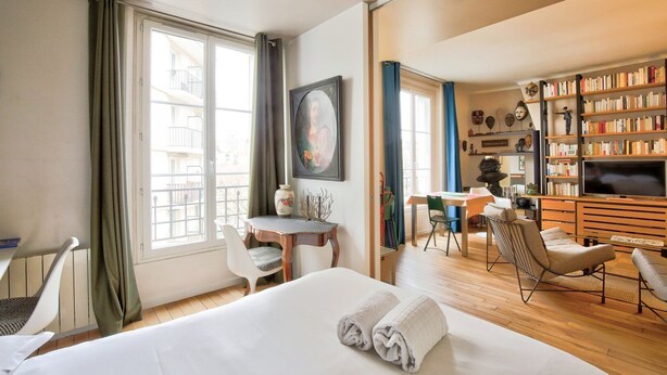 Une chambre d’hôtel comprenant un lit, un bureau, une chaise, une bibliothèque et un téléviseur.
