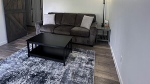 Ein Wohnzimmer mit einer Couch, einem Couchtisch und einem Teppich.